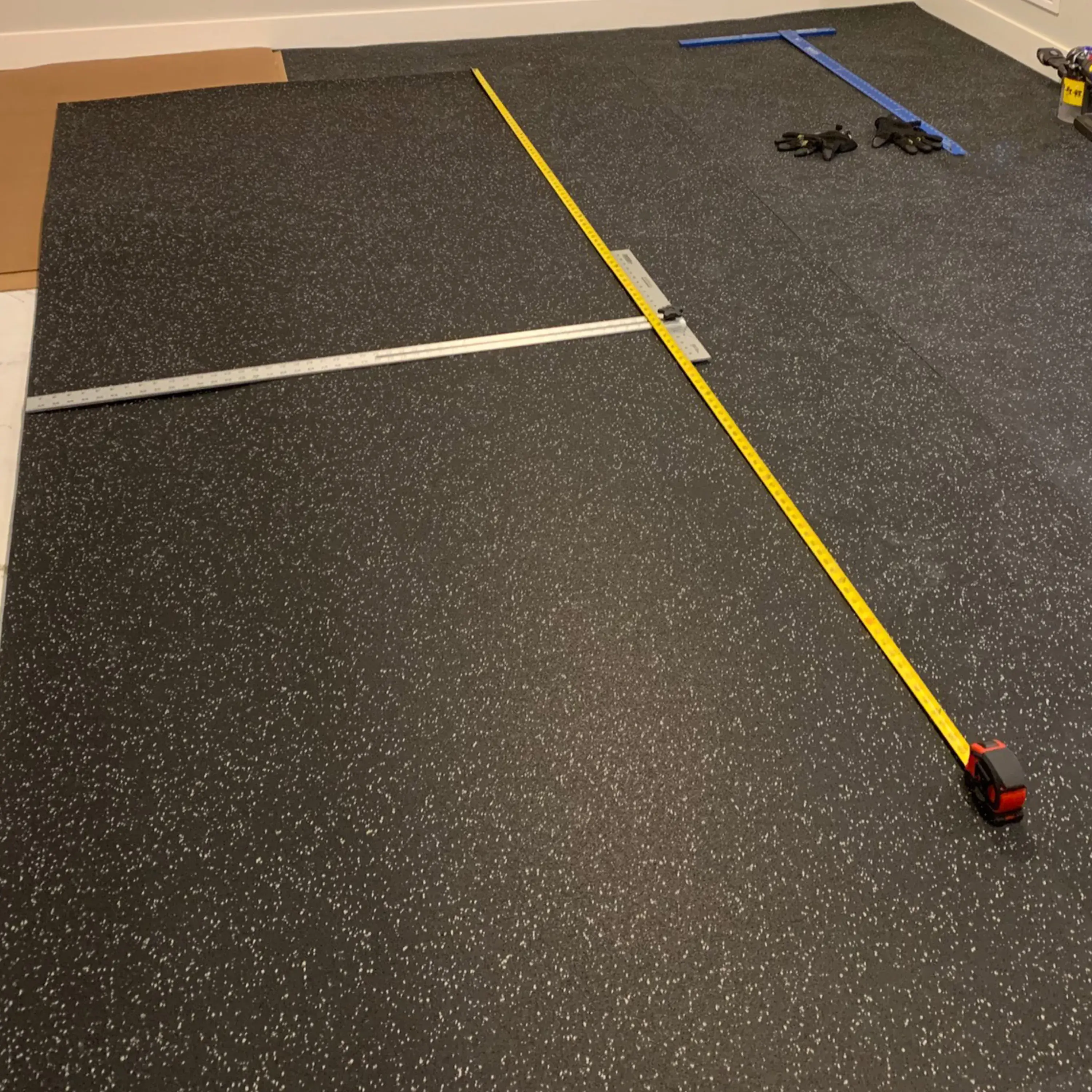 Thick interlocking black rubber tiles applied to a high-traffic athletic center floor.